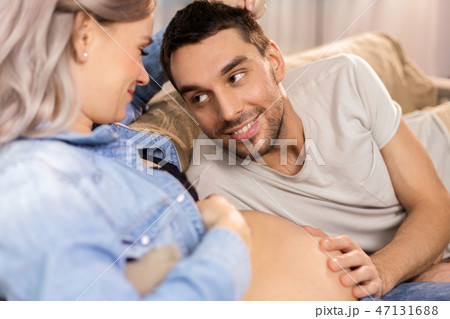 happy man with pregnant woman at home 47131688