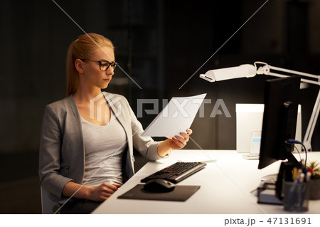 businesswoman with papers working at night office 47131691