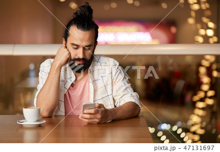 man with coffee and smartphone at restaurant 47131697