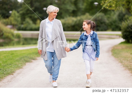 grandmother and granddaughter walking at park grandmother and granddaughter walking at park 47132357