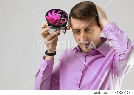 young man leaned against the head of the cooler from computer isolated on a light background young man leaned against the head of the cooler from computer isolated on a light background 47138738