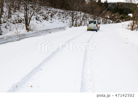 山間道路積雪道上り坂でスタックした四輪駆動車 47142502