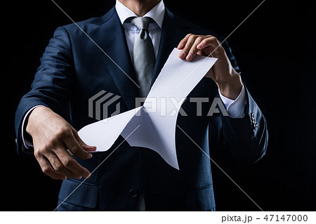 白紙の紙を破るビジネスマンの写真素材