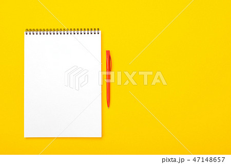 Working space table with notebook and pen with copyspace isolated on yellow background 47148657