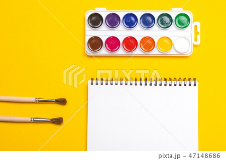 Watercolor paints and brushes with canvas for painting with copyspace on yellow background Watercolor paints and brushes with canvas for painting with copyspace on yellow background 47148686