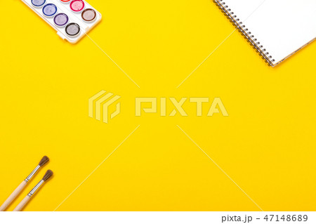 Watercolor paints and brushes with canvas for painting with copyspace on yellow background Watercolor paints and brushes with canvas for painting with copyspace on yellow background 47148689