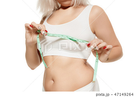 Beauty body care. Woman holding the meter with hands and measuring waist. 47149264