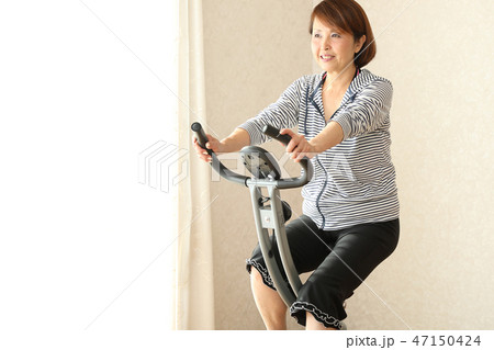 フィットネスバイクで体を鍛える女性 フィットネスバイクで体を鍛える女性 47150424