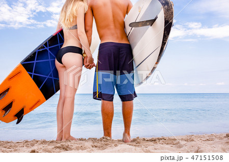 Surfers at the beach- Smiling couple of surfers walking on the beach and having fun in summer 47151508