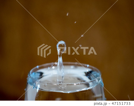 The form of a drop falling into a cup of water 47151733