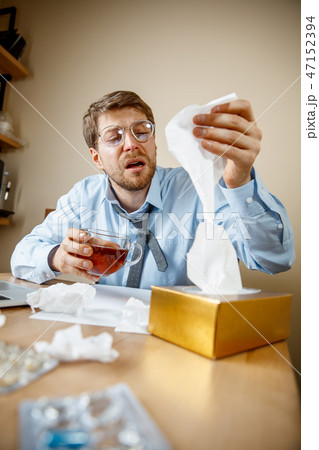Sick man while working in office, businessman caught cold, seasonal flu. 47152394