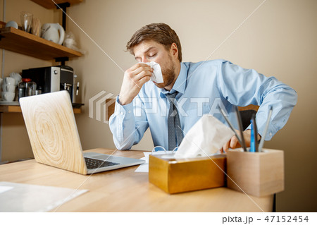 Sick man while working in office, businessman caught cold, seasonal flu. 47152454