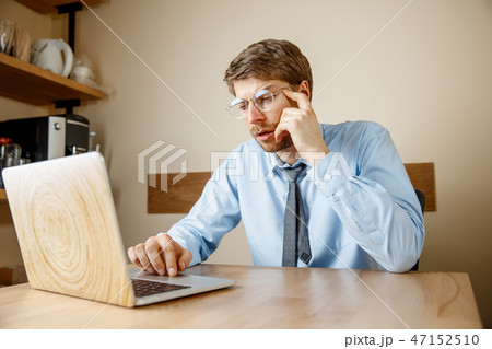 Feeling sick and tired. Frustrated young man massaging his head while sitting at his working place Feeling sick and tired. Frustrated young man massaging his head while sitting at his working place 47152510