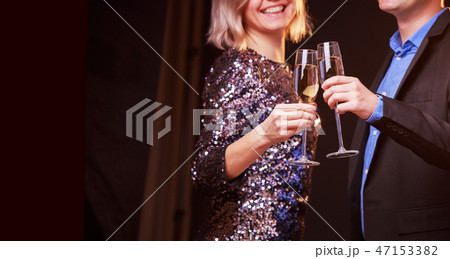 Picture of woman in brilliant dress and men with wine glasses with champagne on black background Picture of woman in brilliant dress and men with wine glasses with champagne on black background 47153382
