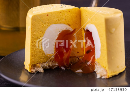 Mango passion fruit cake, is served with a tea tea 47153930