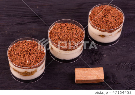 Tiramisu with a chocolate crumb in plastic cups Tiramisu with a chocolate crumb in plastic cups 47154452