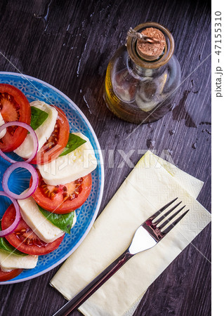 Caprese salad on a blue plate with an ornament on Caprese salad on a blue plate with an ornament on 47155310