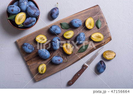 Fresh plums in bowl on wooden table 47156664