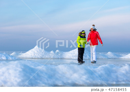 Young mother and her son on icy beach Young mother and her son on icy beach 47158455