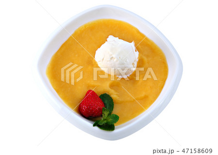 ball of ice cream floats in mango puree, on white. 47158609