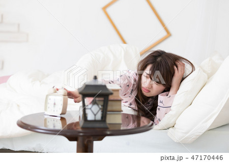 目覚ましを止める女性 47170446
