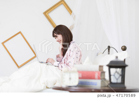 ベッドでパソコンをする女性 ベッドでパソコンをする女性 47170589