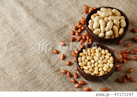 Peanuts in the shell and peeled closeup in a cup Peanuts in the shell and peeled closeup in a cup 47171297