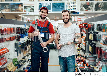Salesman and bearded client posing with wrenches Salesman and bearded client posing with wrenches 47172808
