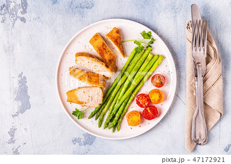 Roasted chicken breast with asparagus and tomatoes 47172921