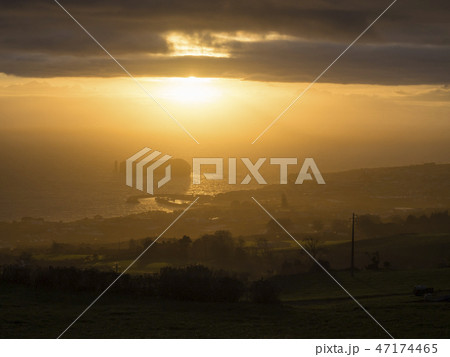 Aerial view of Vila Franca do Campo town volcanic islet during orange sunset with clouds, contre 47174465