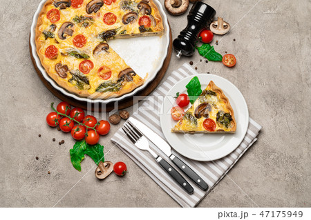 Baked homemade quiche pie in ceramic baking form and slice Baked homemade quiche pie in ceramic baking form and slice 47175949