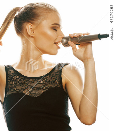 young pretty blond woman singing in microphone isolated close up young pretty blond woman singing in microphone isolated close up 47176262