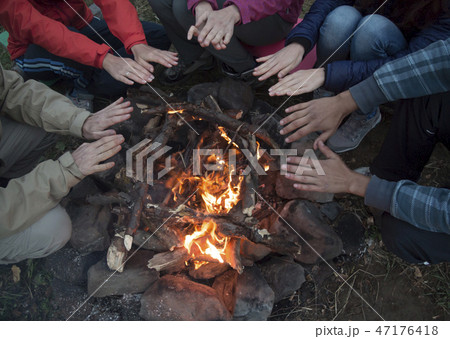 young men and women hands warm by the fire. Travel young men and women hands warm by the fire. Travel 47176418