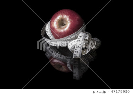 apple surrounded with measurement tape on blac apple surrounded with measurement tape on blac 47179930