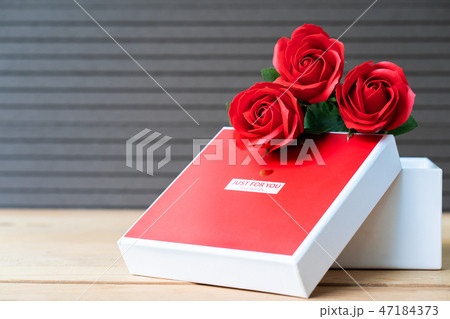 Red roses and heart-shaped box on wood background Red roses and heart-shaped box on wood background 47184373