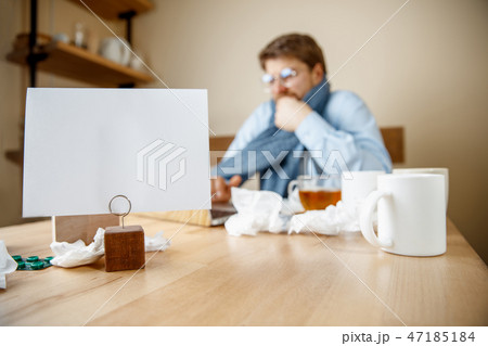 Sick man while working in office, businessman caught cold, seasonal flu. Sick man while working in office, businessman caught cold, seasonal flu. 47185184