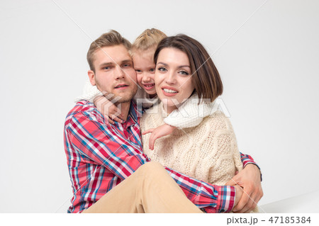 Happy family of three hugging on white background. 47185384