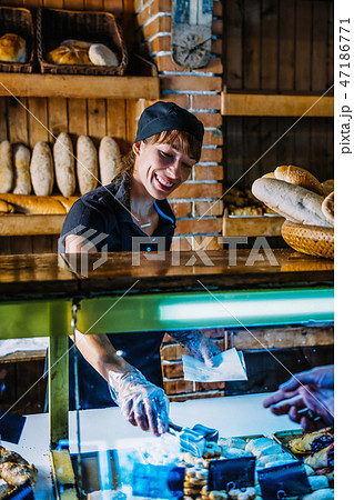 Female Bakery Assistant Working At Bakery Shop 47186771