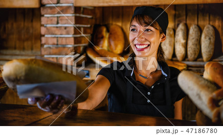 Female Bakery Assistant Working At Bakery Shop Female Bakery Assistant Working At Bakery Shop 47186780