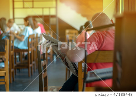 Old man sitting in the coffee shop and reading Old man sitting in the coffee shop and reading 47188448