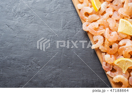 Shrimp with spices and lemon on a wooden Board.  47188664