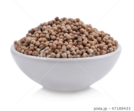 Coriander seeds in a cup of white background 47189433