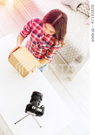 Cute and funny little blogger feeling curious while getting her present box Cute and funny little blogger feeling curious while getting her present box 47193830