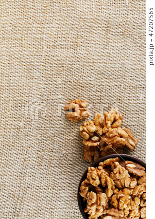 Peeled walnuts in a wooden, dark brown cup on 47207565