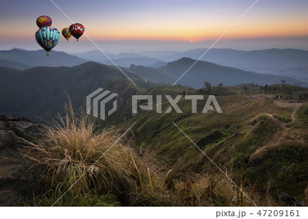 Hot air balloon flying over the peak of mountain Hot air balloon flying over the peak of mountain 47209161