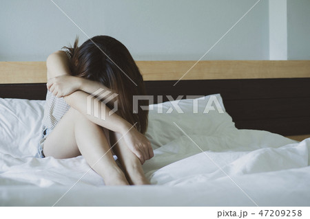 Depressed woman sitting on the bed Depressed woman sitting on the bed 47209258