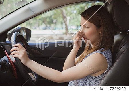 Young woman holding her nose because of bad smell  Young woman holding her nose because of bad smell  47209266