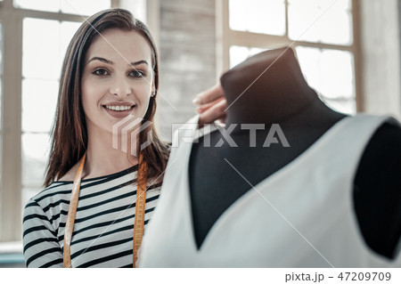 Fashion designer wearing striped shirt sewing bridal dress Fashion designer wearing striped shirt sewing bridal dress 47209709