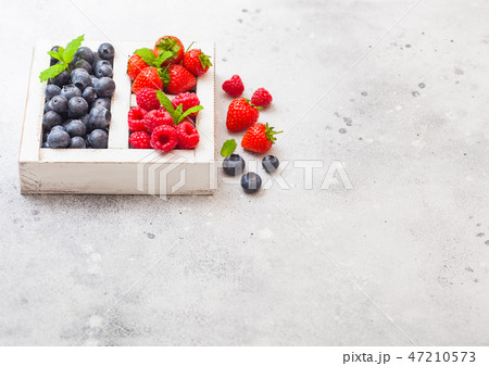 Fresh raw organic berries in white wooden box Fresh raw organic berries in white wooden box 47210573