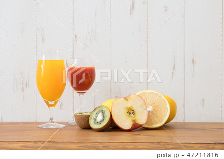 フルーツジュースとフルーツをお洒落な壁に置くの写真素材